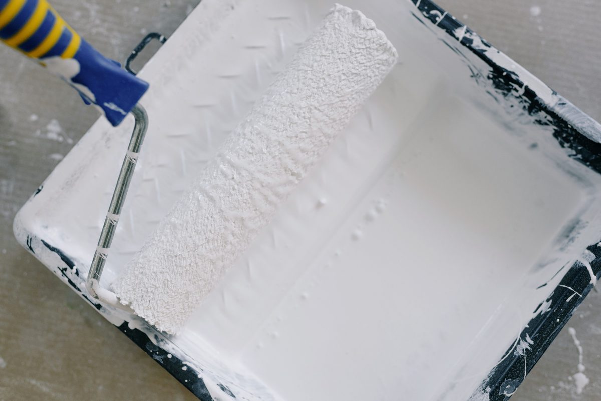 Roller and tray with white paint prepared for wall painting